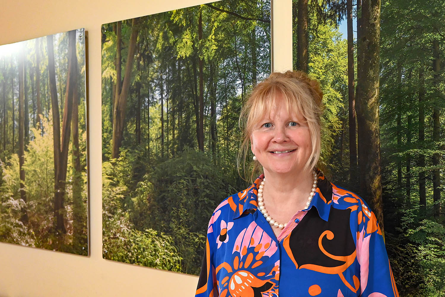 Die BLV-Vorstandsvorsitzende Christine Jung-Weyand vor einem Waldbild-Triptychon von Fotograf Holger Tuttas.